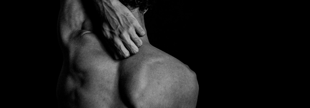 topless man covering face with both hands