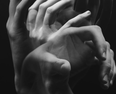 A monochromatic image capturing the fluid motion of hands in a conceptual style.