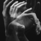 A monochromatic image capturing the fluid motion of hands in a conceptual style.