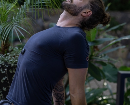 a man sitting on a yoga mat in the middle of a forest