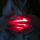 A close-up of hands holding a glowing red heart, symbolizing love and energy.
