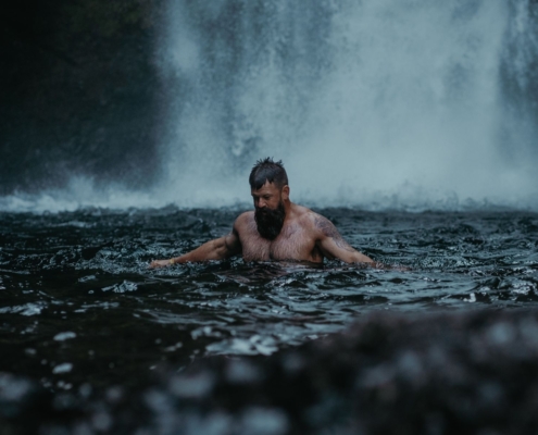 Adult male enjoying a relaxing swim in the Cascade Locks waterfall in Oregon, USA.