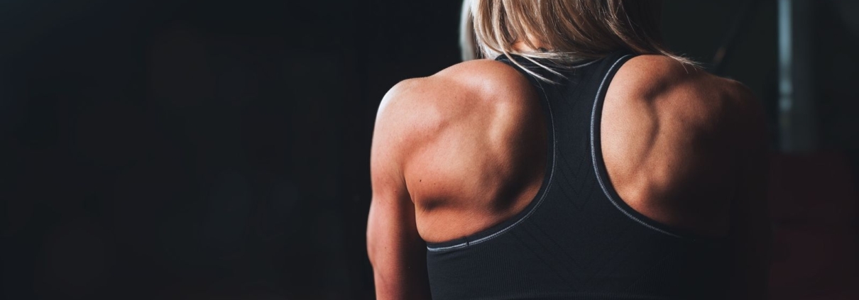 A powerful back view of a female bodybuilder showcasing muscular definition and strength.